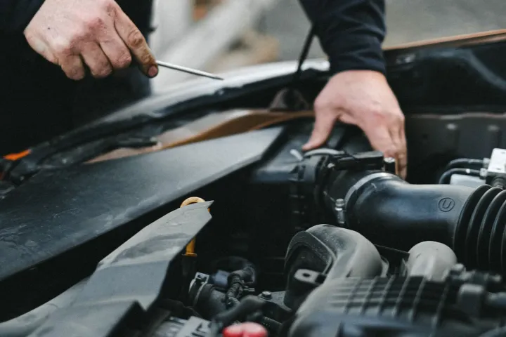 Mechanic checking components in a car engine bay