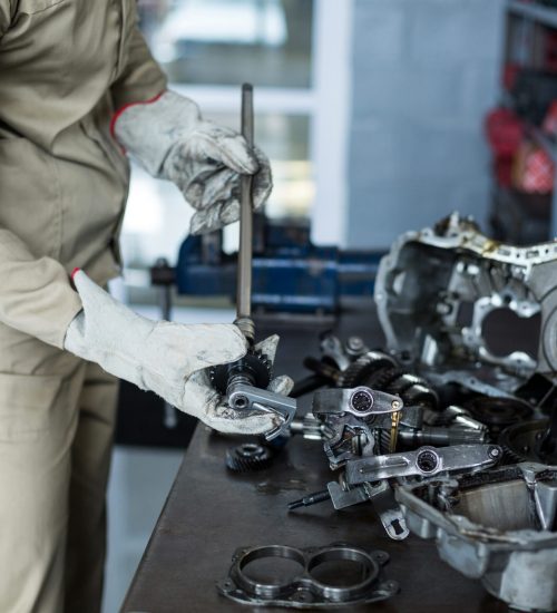 Mechanic checking a car parts in repair shop